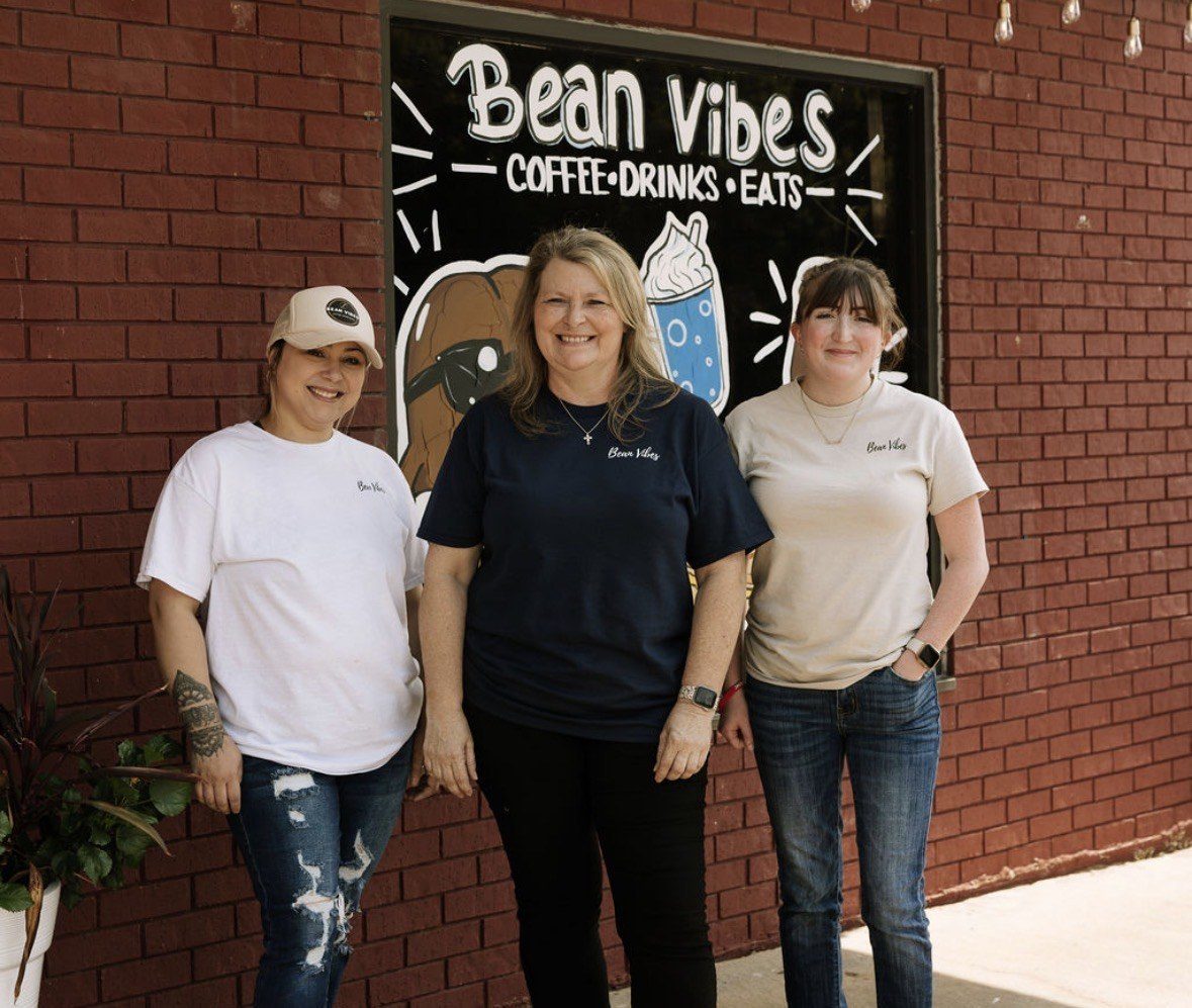 The Bean Vibes team out front under the painted sign